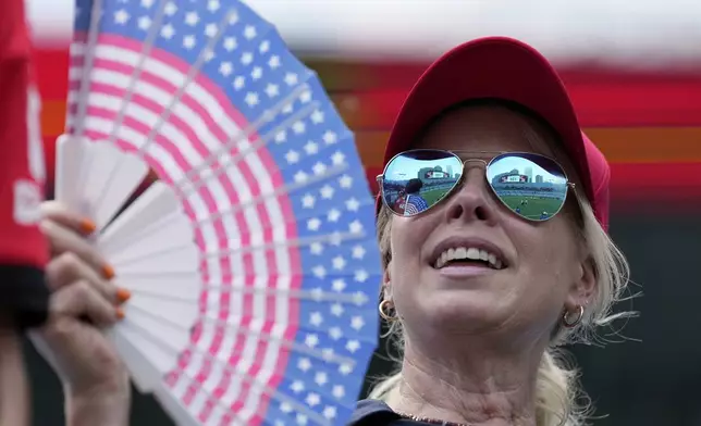 A fan tries to keep cool before the Club World Cup Group C soccer match between Benfica and Bayern Munich in Charlotte, N.C., Tuesday, June 24, 2025. (AP Photo/Chris Carlson)