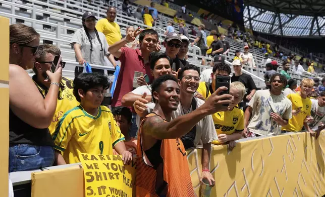 Mamelodi Sundowns' Lucas Ribeiro Costa (10) poses for a selfie with fans after the Club World Cup Group F soccer match between Mamelodi Sundowns and Borussia Dortmund in Cincinnati, Saturday, June 21, 2025. (AP Photo/Carolyn Kaster)