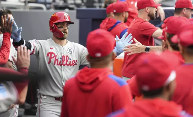 Philadelphia Phillies' Bryce Harper (3) celebrates in the dugout after hitting a solo home run off Toronto Blue Jays pitcher Bowden Francis during the first inning of a baseball game in Toronto, Tuesday June 3, 2025. (Chris Young/The Canadian Press via AP)