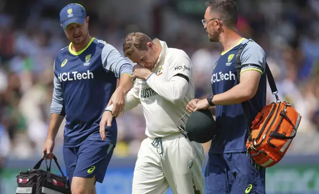 Australia's Steve Smith reacts in pain as he leaves the field after getting hurt while fielding on day three of the World Test Championship final between South Africa and Australia at Lord's cricket ground in London, Friday, June 13, 2025. (AP Photo/Kirsty Wigglesworth)