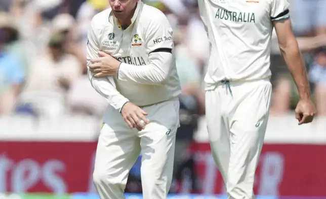 Australia's Steve Smith, left, reacts in pain after getting hurt while fielding on day three of the World Test Championship final between South Africa and Australia at Lord's cricket ground in London, Friday, June 13, 2025. (AP Photo/Kirsty Wigglesworth)