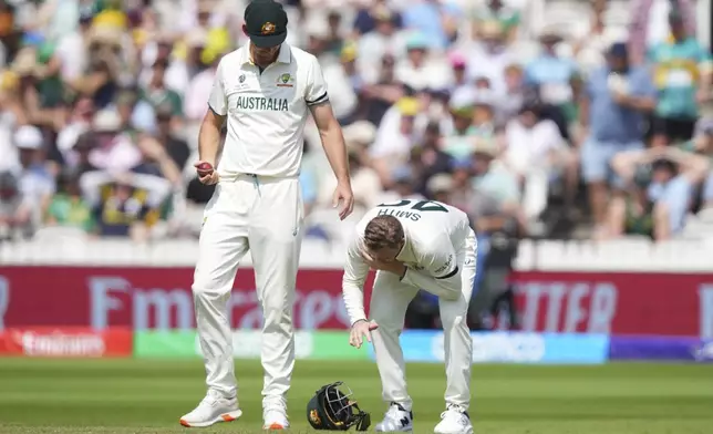 Australia's Steve Smith, right, reacts in pain after getting hurt while fielding on day three of the World Test Championship final between South Africa and Australia at Lord's cricket ground in London, Friday, June 13, 2025. (AP Photo/Kirsty Wigglesworth)