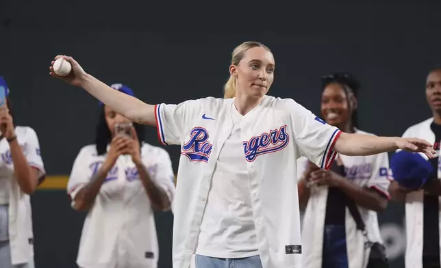 Dallas Wings' Paige Bueckers prepares to throw the first pitch before a baseball game between the Kansas City Royals and Texas Rangers, Wednesday, June 18, 2025, in Arlington, Texas. (AP Photo/LM Otero)
