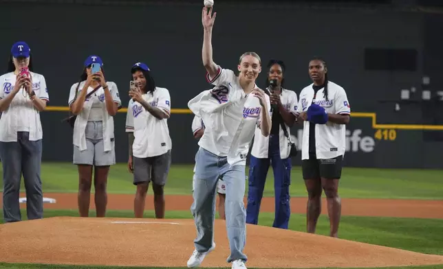 Dallas Wings' Paige Bueckers throws the first pitch in front of teammates before a baseball game between the Kansas City Royals and Texas Rangers, Wednesday, June 18, 2025, in Arlington, Texas. (AP Photo/LM Otero)