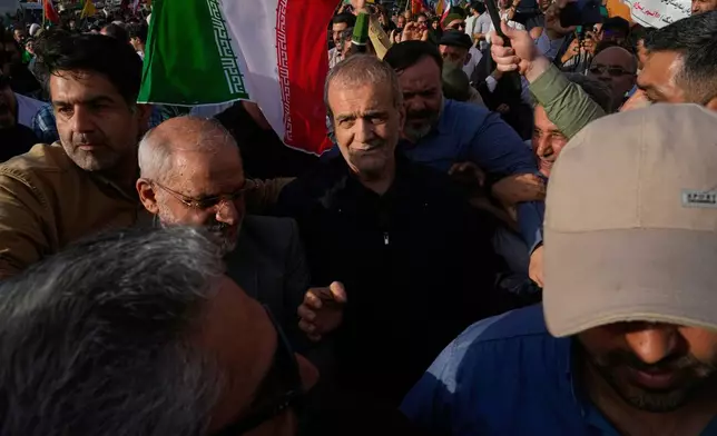 Iranian President Masoud Pezeshkian, center, attends a protest following the U.S. attacks on nuclear sites in Iran, in Tehran, Iran, Sunday, June 22, 2025. (AP Photo/Vahid Salemi)