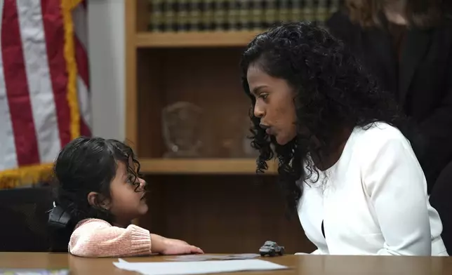 Deysi Vargas, left, talks to her 4-year-old daughter, who has short bowel syndrome, at a news conference in Los Angeles, Wednesday, May 28, 2025, after their humanitarian parole was terminated and they were ordered to self-deport. (AP Photo/Jae C. Hong)