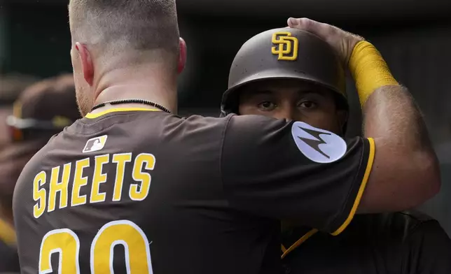 San Diego Padres' Luis Arraez, right, is embraced by Gavin Sheets (30) after hitting a solo home run during the fifth inning of a baseball game against the Cincinnati Reds, Saturday, June 28, 2025, in Cincinnati. (AP Photo/Jeff Dean)