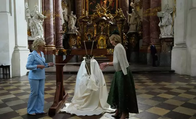 Queen Maxima of The Netherlands, right, and Czech Republic's first lady Eva Pavlova unveil a bell, that was made from weapons used in Ukraine's war, during a blessing ceremony in Prague, Czech Republic, Thursday, June 5, 2025. (AP Photo/Petr David Josek)