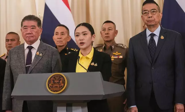 Thailand's Prime Minister Paetongtarn Shinawatra, center, talks to reporters at Government house in Bangkok, Thailand, Thursday, June 19, 2025. (AP Photo/Sakchai Lalit)