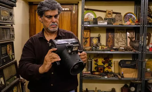Aditya Vij, an Indian anthropologist and an avid collector of artifacts, shows the Graflex hand held aircraft camera used by the U.S. Army Air Corps during World War II, in his house in New Delhi, India, April 18, 2025. (AP Photo/Manish Swarup)