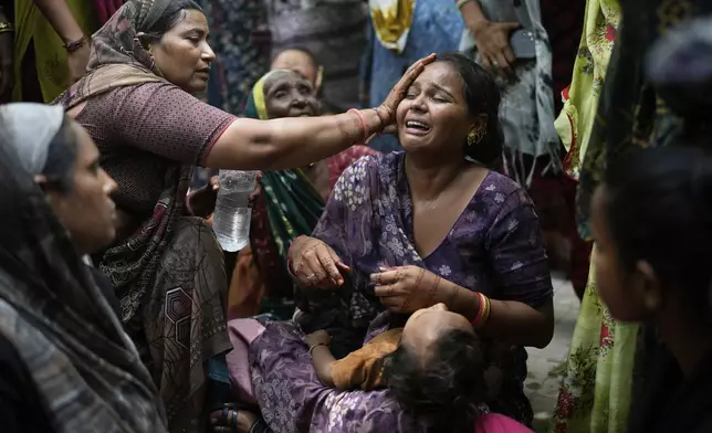 A relative of a victim of the Air India plane crash is comforted as she breaks down at a hospital in Ahmedabad, India, Friday, June 13, 2025. (AP Photo/Rafiq Maqbool)