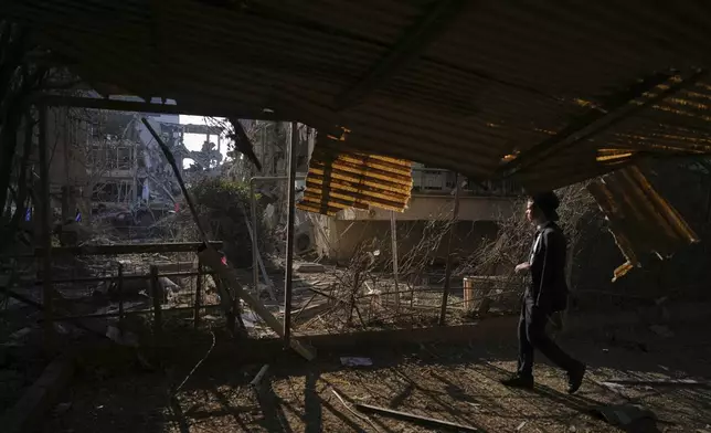 A person looks out at a destroyed residential building that was hit by a missile fired from Iran, in Ramat Gan, near Tel Aviv, Israel, on Saturday, June 14, 2025. (AP Photo/Ariel Schalit)