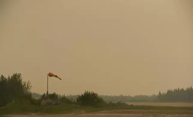 Smoke filled skies from out of control wildfires in Norway House, Manitoba Tuesday, June 3, 2025, at the Norway House Airport as crews continue to fight wildfires in northern Manitoba. (David Lipnowski/The Canadian Press via AP)