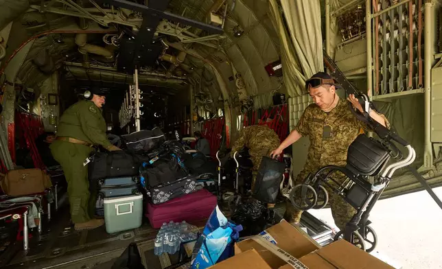 Royal Canadian Air Force Cpl. Ethan Cai helps load cargo as evacuees from Pinaow Wachi Care Home board a C-130 Hercules aircraft in Norway House, Manitoba, Tuesday, June 3, 2025, at the Norway House Airport as crews continue to fight wildfires in northern Manitoba. (David Lipnowski/The Canadian Press via AP)
