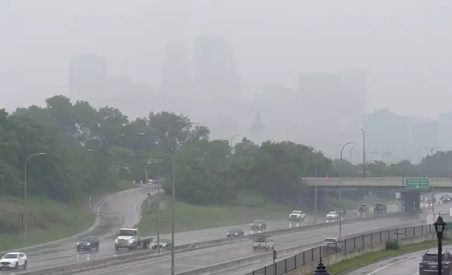 Smoke from wildfires burning in Canada and rain obscures the downtown skyline of Minneapolis, Minn., on Tuesday, June 3, 2025. (AP Photo/Mark Vancleave)