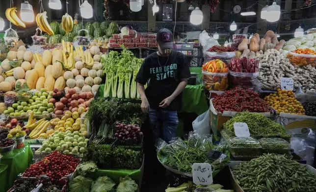 A fruit and vegetable vendor waits for customers in Tajrish traditional bazaar in northern Tehran, Iran, Monday, June 2, 2025. (AP Photo/Vahid Salemi)