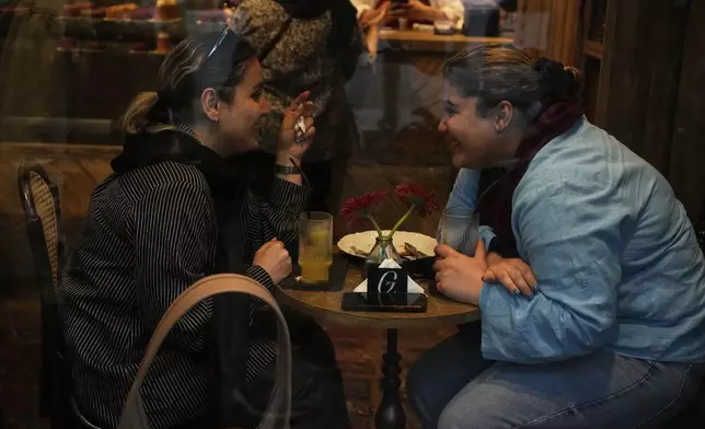 Women enjoy their time in a café in northern Tehran, Iran, Monday, June 2, 2025. (AP Photo/Vahid Salemi)