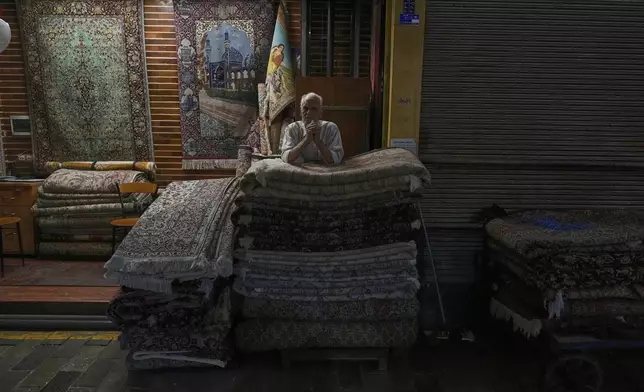A carpet seller stands at his shop at Tehran's old main bazaar, Iran, Monday, May 5, 2025. (AP Photo/Vahid Salemi)