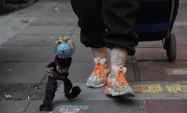 A street vendor displays her puppet on a sidewalk in northern Tehran, Iran, Monday, June 2, 2025. (AP Photo/Vahid Salemi)