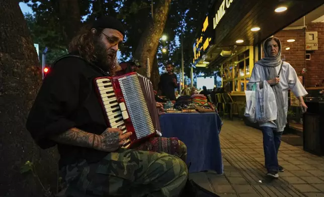 A street musician plays music on a sidewalk in northern Tehran, Iran, Wednesday, April 30, 2025. (AP Photo/Vahid Salemi)
