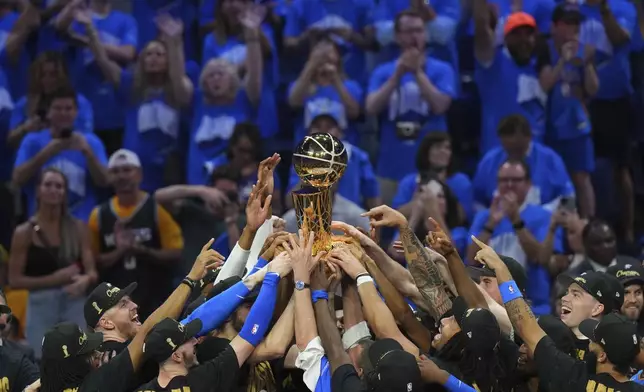 Oklahoma City Thunder players hold up the Larry O'Brien Championship Trophy after they won the NBA basketball championship with a Game 7 victory against the Indiana Pacers Sunday, June 22, 2025, in Oklahoma City. (AP Photo/Nate Billings)