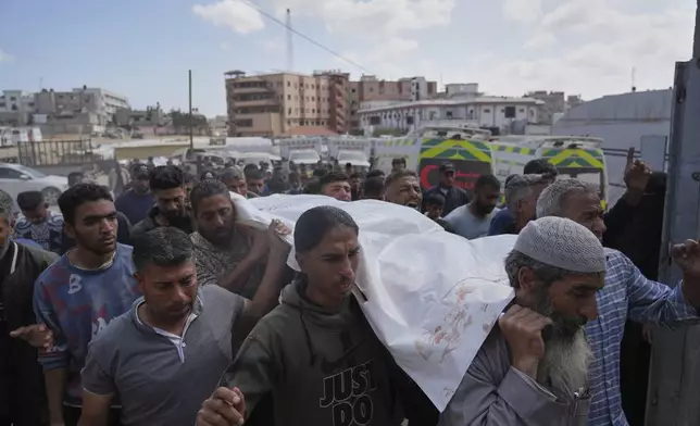 Palestinians carry the body of Reem Al-Akhras who was killed while heading to a Gaza aid hub, during her funeral in Khan Younis, southern Gaza Strip, Tuesday, June 3, 2025. (AP Photo/Abdel Kareem Hana)