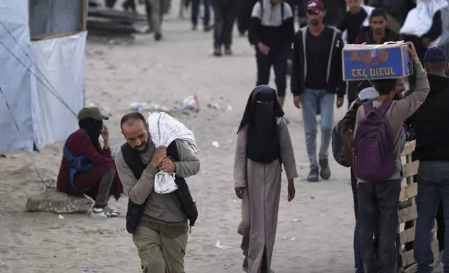 Palestinians carry bags filled with food and humanitarian aid provided by the Gaza Humanitarian Foundation, a U.S.-backed organization approved by Israel, in Khan Younis, southern Gaza Strip, on Tuesday, June 3, 2025. (AP Photo/Abdel Kareem Hana)