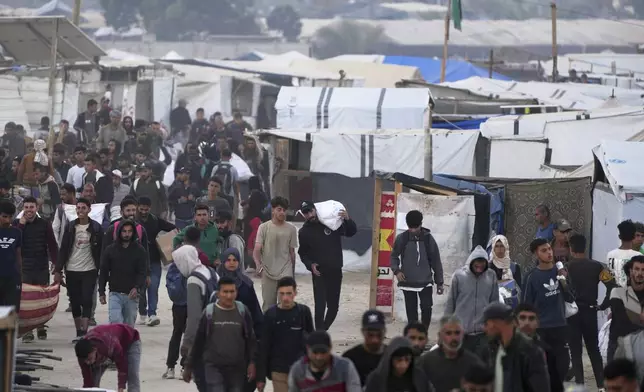 Palestinians carry bags filled with food and humanitarian aid provided by the Gaza Humanitarian Foundation, a U.S.-backed organization approved by Israel, in Khan Younis, southern Gaza Strip, on Tuesday, June 3, 2025. (AP Photo/Abdel Kareem Hana)