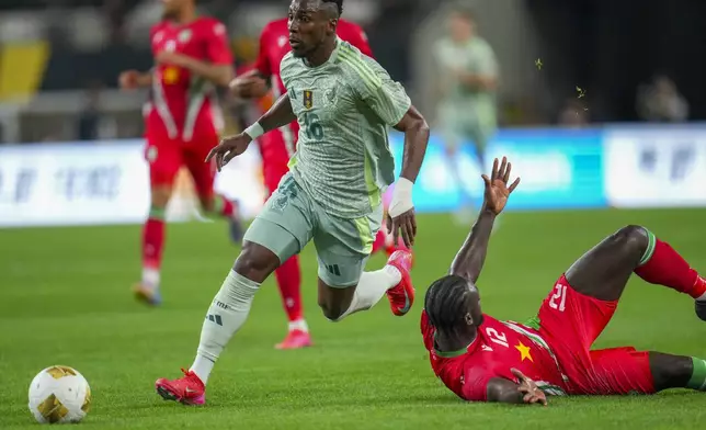 Mexico forward Julián Quiñones (16) runs with the ball as Suriname defender Leo Abena (12) drops to the ground during a CONCACAF Gold Cup soccer match Wednesday, June 18, 2025, in Arlington, Texas. (AP Photo/Julio Cortez)