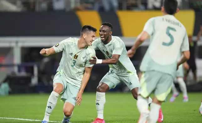 Mexico defender César Montes, left, celebrates his side's second goal with teammate Julián Quiñones during a CONCACAF Gold Cup soccer match against Suriname Wednesday, June 18, 2025, in Arlington, Texas. (AP Photo/Julio Cortez)