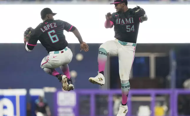 Miami Marlins shortstop Otto Lopez (6) and right fielder Dane Myers (54) celebrate after the Marlins defeated the San Francisco Giants during the of a baseball game, Saturday, May 31, 2025, in Miami. (AP Photo/Lynne Sladky)