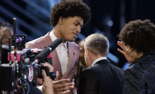 Joan Beringer, left, reacts after being selected 17th by the Minnesota Timberwolves in the first round of the NBA basketball draft, Wednesday, June 25, 2025, in New York. (AP Photo/Adam Hunger)