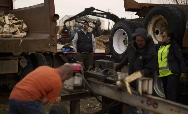 Tim Kalke, general manager of Sustainable Energy for Galena, Alaska, watches as some of his workers split logs Monday, May 19, 2025, in Galena. (AP Photo/John Locher)