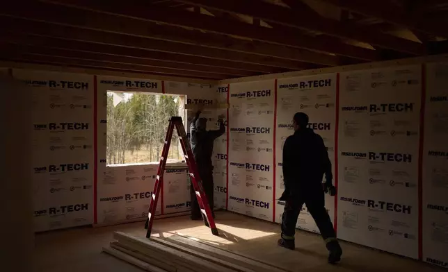 Joe Cleaver II, left, and Derrick Esmailka build an energy efficient home Thursday, May 22, 2025, in Galena, Alaska. (AP Photo/John Locher)