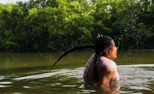 Sevlin Mendez cools off in the Harpeth River as the heat index reaches 100 degrees Fahrenheit, Wednesday, June 25, 2025, in Nashville, Tenn. (AP Photo/George Walker IV)