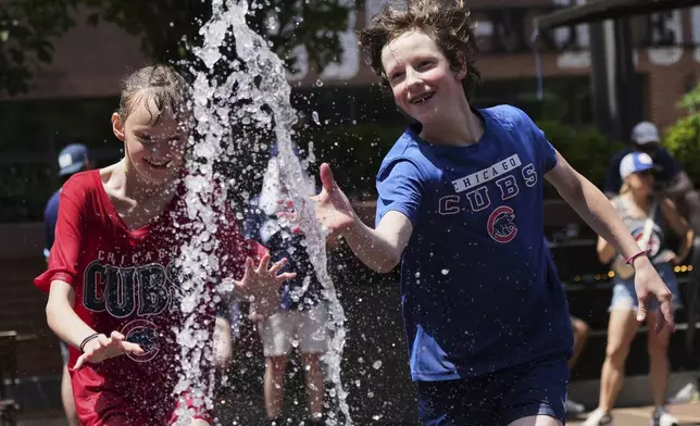 Kid cool off at a fountain during hot weather in Chicago, Sunday, June 22, 2025. (AP Photo/Nam Y. Huh)