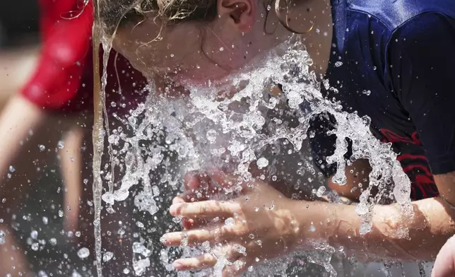 Jude Puroway cools off at a fountain during hot weather in Chicago, Sunday, June 22, 2025. (AP Photo/Nam Y. Huh)