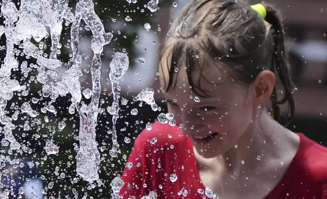 Bay Puro cools off at a fountain during hot weather in Chicago, Sunday, June 22, 2025. (AP Photo/Nam Y. Huh)