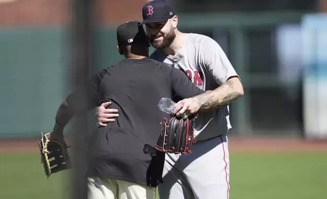 San Francisco Giants' Rafael Devers, left, hugs Boston Red Sox pitcher Lucas Giolito before a baseball game in San Francisco, Friday, June 20, 2025. (AP Photo/Jeff Chiu)