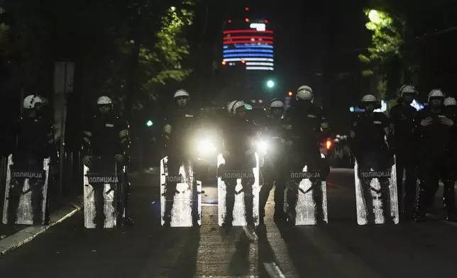 Riot police block a street to prevent clashes between anti-government protesters and government supporters at the end of a rally pressing for an early election after nearly eight months of almost daily anti-corruption demonstrations that have shaken the populist government of President Aleksandar Vucic, in Belgrade, Serbia, Saturday, June 28, 2025. (AP Photo/Darko Vojinovic)