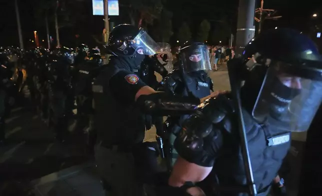 Riot police prepare to charge protesters at the end of an anti-government rally pressing for an early election after nearly eight months of almost daily anti-corruption demonstrations that have shaken the populist government of President Aleksandar Vucic, in Belgrade, Serbia, Saturday, June 28, 2025. (AP Photo/Darko Vojinovic)