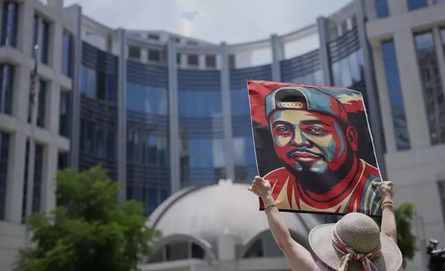 Katheryn Millwee holds a portrait of Kilmar Abrego Garcia outside the federal courthouse Wednesday, June 25, 2025, in Nashville, Tenn. (AP Photo/George Walker IV)