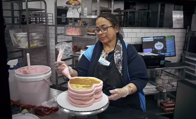 An employee makes a cake inside Walmart Supercenter on Wednesday, May 28, 2025, in North Bergen, N.J. (AP Photo/Andres Kudacki)