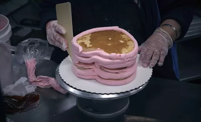An employee makes a cake inside Walmart Supercenter on Wednesday, May 28, 2025, in North Bergen, N.J. (AP Photo/Andres Kudacki)
