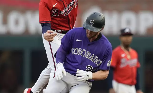 Atlanta Braves shortstop Nick Allen (2) attempts a tag on Colorado Rockies' Ryan McMahon (24) third inning of a baseball game, Friday, June 13, 2025, in Atlanta. (AP Photo/Mike Stewart)