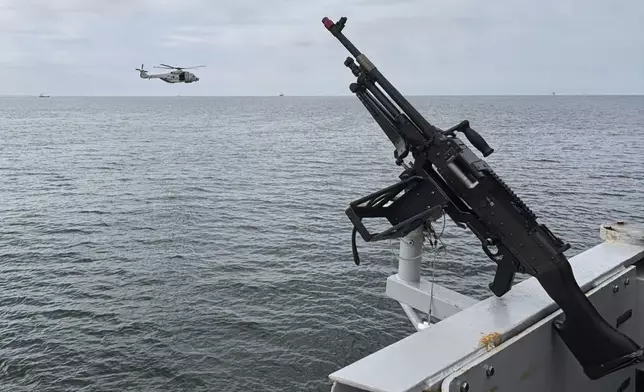 A helicopter flies by the HNLMS Tromp, a Royal Netherlands Navy guided missile frigate, patrolling on the North Sea ahead of the NATO summit in The Hague, Netherlands, Thursday, June 19, 2025. (AP Photo/Aleksandar Furtula)