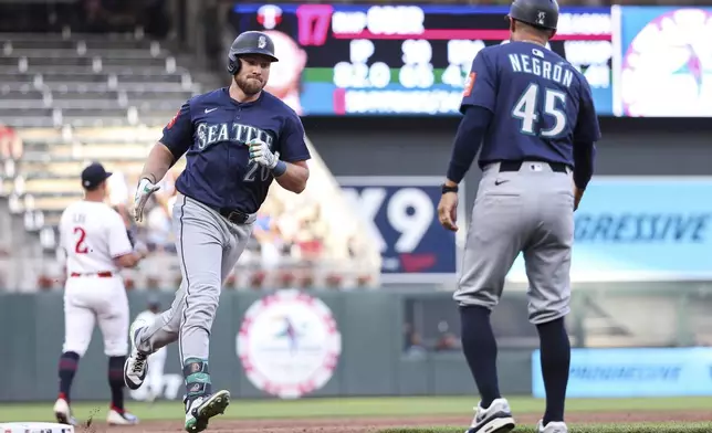 Seattle Mariners' Luke Raley (20) celebrates his three run home run as he runs the bases during the third inning against the Minnesota Twins of baseball game Monday, June 23, 2025, in Minneapolis. (AP Photo/Matt Krohn)