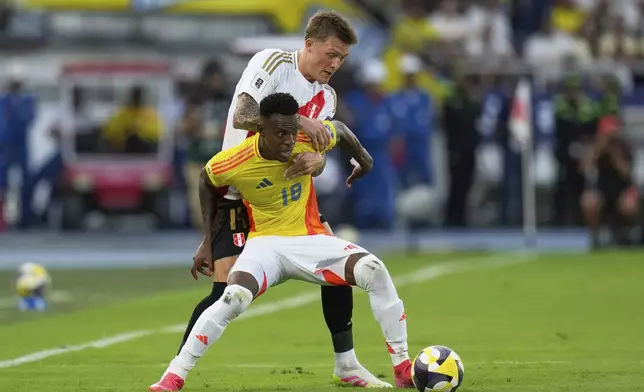 Colombia's Cristian Borja, front, and Peru's Oliver Sone battle for the ball during a World Cup 2026 qualifying soccer match at Metropolitano stadium in Barranquilla, Colombia, Friday, June 6, 2025. (AP Photo/Fernando Vergara)