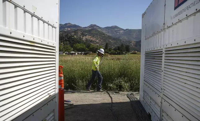 A worker lays cables at Energy Vault, a company that is creating an emergency power system that relies on hydrogen and battery storage, on Tuesday, May 27, 2025, in Calistoga, Calif. (AP Photo/Annika Hammerschlag)