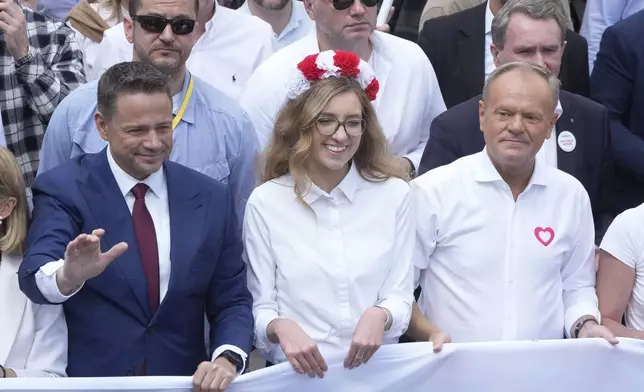The liberal presidential candidate Rafal Trzaskowski, front left, waves as he and Polish prime minister Donald Tusk, front right, take part in a march one week ahead of a decisive presidential election in Warsaw, Poland on Sunday, May 25, 2025. (AP Photo/Czarek Sokolowski)